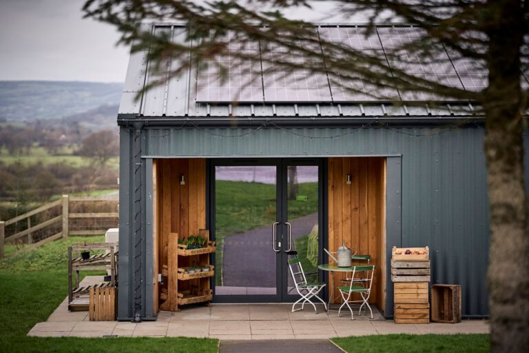 A large modern building with bright windows in a rural setting