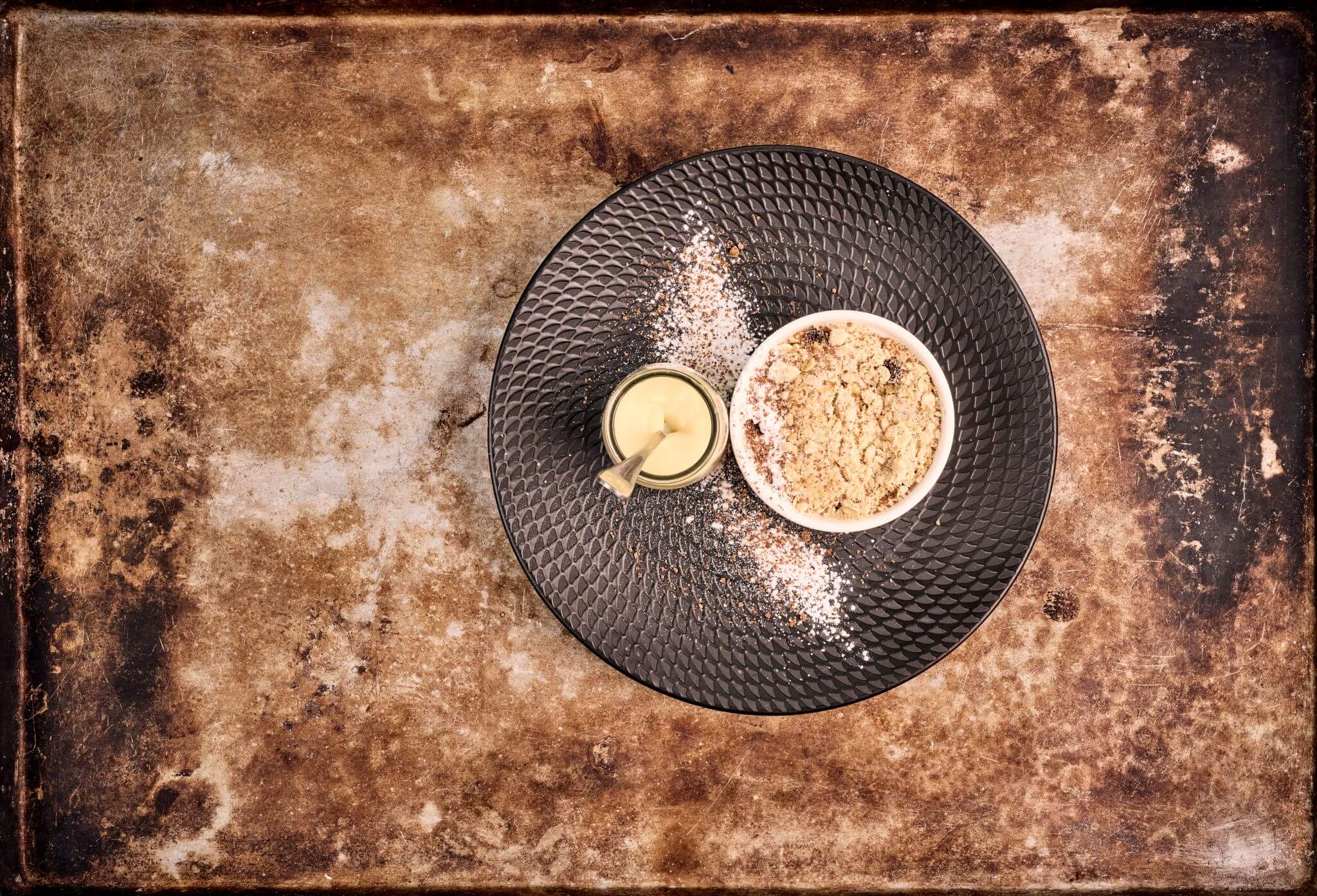 A traditional British crumble dessert with a side of custard, artfully decorated and looking beautiful on the plate