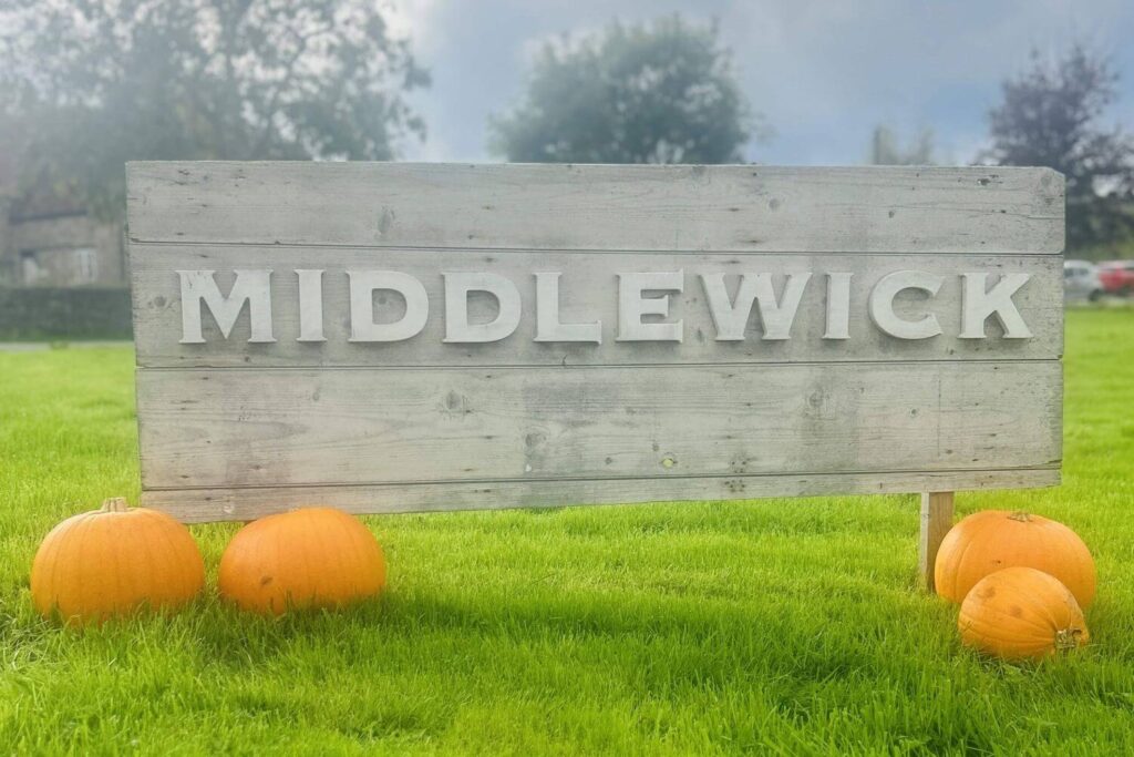 Display of fresh pumpkins in front of the Middlewick sign.