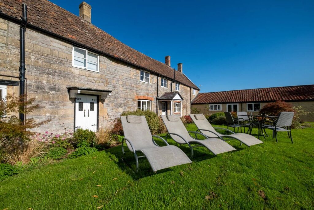 Lawn chairs on rich green grass outside of Blenheim Cottage at The Middlewick